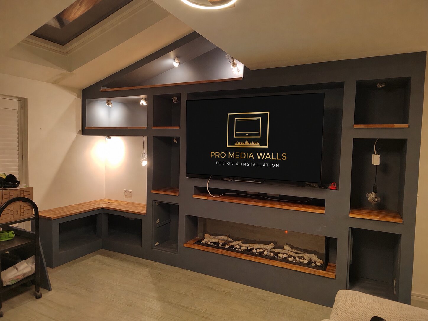 Warm-toned bespoke media wall with recessed television and electric fireplace